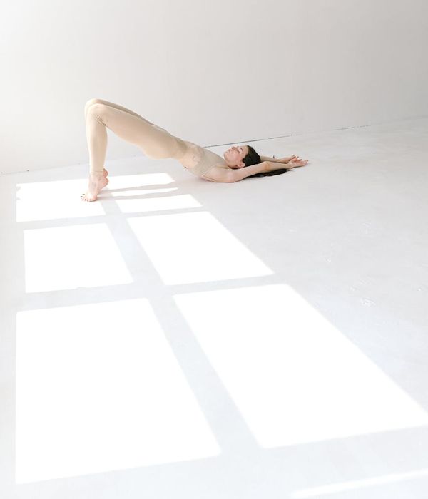 Woman in a peaceful yoga pose in a bright, serene studio.